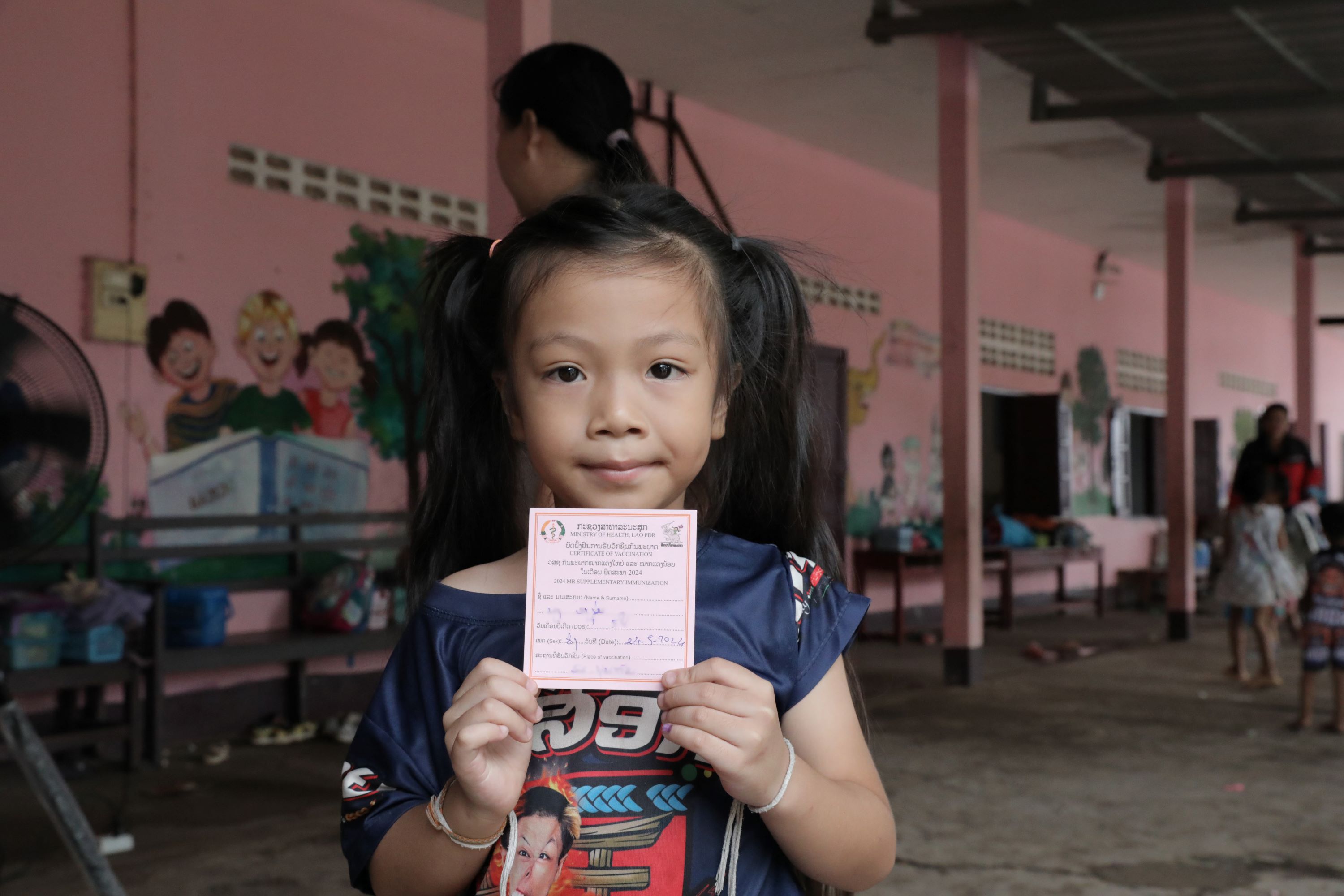 A young child holding a piece of paperDescription automatically generated